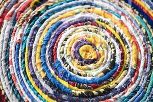 Background roll of twisted fabric close-up. Many rags of different colors photo