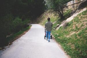 Person walking on a peaceful path in nature pushing a stroller, surrounded by trees and greenery photo