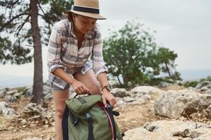 Woman preparing for a hike in nature with a green backpack photo