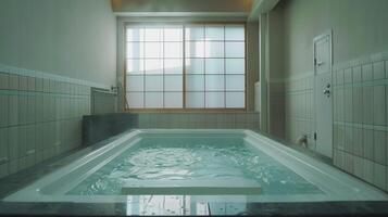 Empty hot tub with rippling water and large window in a spa setting photo