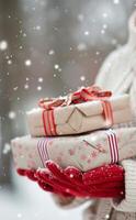 Festive Gifts Wrapped in Colorful Paper Held by Gloved Hands in a Snowy Winter Wonderland photo
