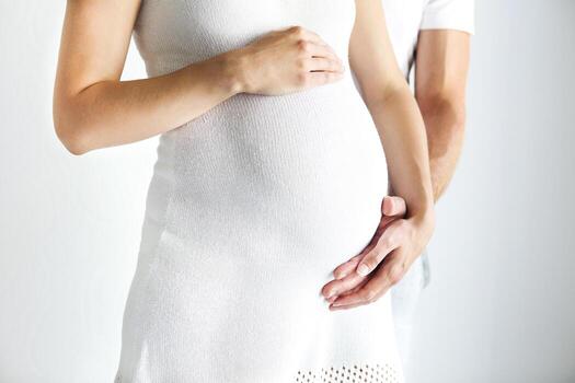 Young man and pretty pregnant woman hugging together photo