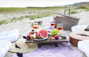 Picnic on the beach at sunset in the style of boho photo