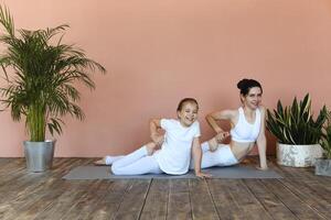 Smiling mother and daughter practicing yoga together photo