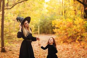 Mother and daughter sweeping path on Halloween day photo