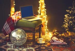 New Year's eve or Christmas still life with retro phone, disco ball, coffee, candle and blanket photo