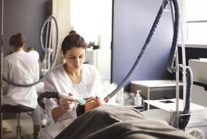 Cosmetician working with client in clinic photo