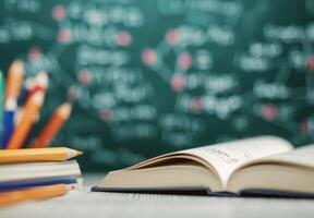 Open Book On Stack Of Textbooks With Chalkboard Background And Blurred Lights photo
