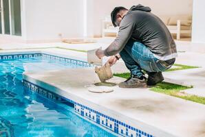 Man cleaning swimming pool garbage filter. Worker removing trash from swimming pool filter basket photo
