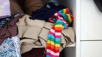 Messy closet with piled clothes and colorful accessories, displaying chaos and disorder in storage video
