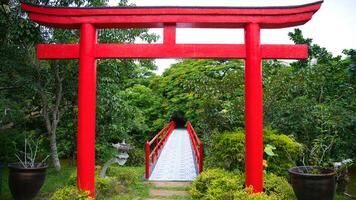 a red tori gate in the middle of a field photo