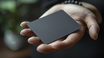 Businessman holding a blank black business card in his hand. Close up. photo