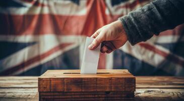 Hand Placing Ballot in Wooden Box With UK Flag Background photo
