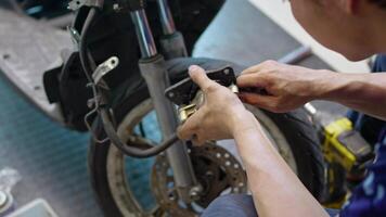 Motorcycle mechanic working in garage check and replace motorcycle brake pads.Maintenance and repir motorcycle service concept, video