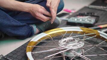 mechanic man work in garage , process of attaching the rim to the hub using spokes and nipples as fasteners, Repair or maintenance concept video