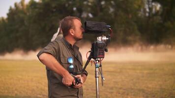 Focus puller at work, rotate the focus wheel. Trucks passing in the background video