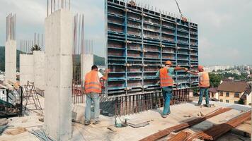 Builders install a large metal structure for pouring monolith. Construction work at the construction site. Work of builders. video