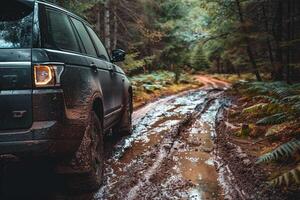 Powerful Full size SUV parked at an off road trailhead with rugged terrain and muddy tracks leading into dense forest photo