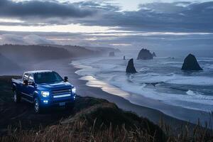 Powerful Full size truck parked on cliffside overlooking rugged coastline with crashing waves and dramatic sestacks in the background photo