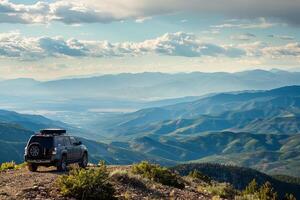 Powerful Full size SUV parked at rugged mountain overlook with panoramics of valleys and distant peaks photo