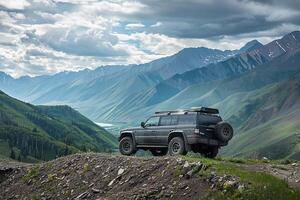 Powerful Full size SUV parked at rugged mountain overlook with panoramics of valleys and distant peaks photo
