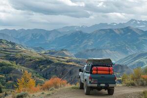 Utility Compact truck loaded with camping gear parked at scenic overlook with panoramics of mountain range photo