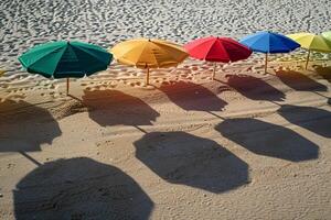 Calmness at the beach with row of beach umbrellas casting colorful shadows on the sand photo