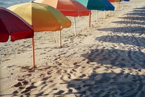 Calmness at the beach with row of beach umbrellas casting colorful shadows on the sand photo