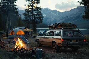 Station Wagon Loaded with Camping Gear Parked at a Nature Campsite with a Bonfire and Tents in the Background photo