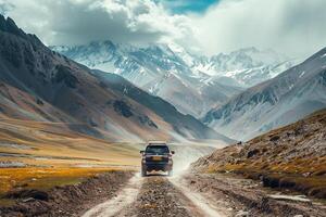 SUV Driving Through Rugged Mountain Pass with Snow capped Peaks Featuring nature background and Adventure photo