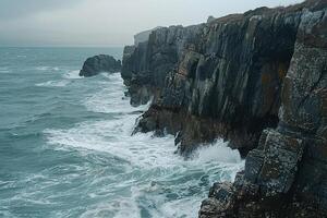 Patterns of waves crashing on rocky shoreline creating foam patterns against the rugged cliffs   nature background photo