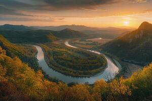Inspiring Panoramic of Lush Green Valley with River Winding Through Surrounded by Colorful Autumn Trees and Distant Mountains Under Golden Sunset Sky nature background photo
