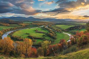 Inspiring Panoramic of Lush Green Valley with River Winding Through Surrounded by Colorful Autumn Trees and Distant Mountains Under Golden Sunset Sky nature background photo
