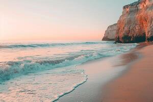 Gentle Waves and Sandy Beach Framed by Rocky Cliffs with Pastel Sunset Sky nature background photo
