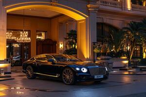 High End Sedan Parked at Entrance of Prestigious Luxury Hotel with Valet photo