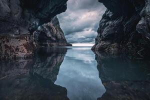 Storm clouds mirrored in the dark waters of secave entrance during tempest photo