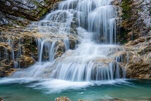 Crystal clear waterfall cascading into a turquoise pool nature background photo
