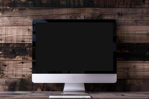 Computer monitor mockup with blank screen on deep walnut wood background photo