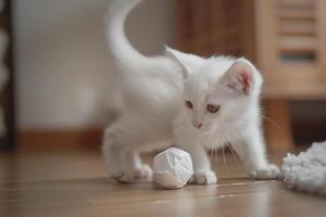 White Kitten Enthusiastically Playing with a Paper Ball in a Cozy and Interactive Environment photo