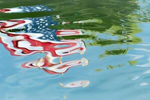 American flag reflected in water with ripples creating a  and distorted visual effect photo