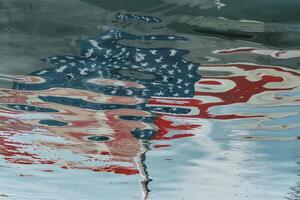 American flag reflected in water with ripples creating a captivating and distorted pattern photo