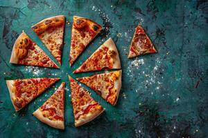 Asymmetrical arrangement of pizza slices on a teal textured background photo