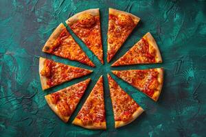 Asymmetrical arrangement of pizza slices on a teal textured background photo