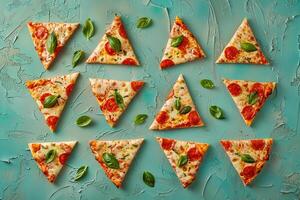 Asymmetrical arrangement of pizza slices on a teal textured background photo