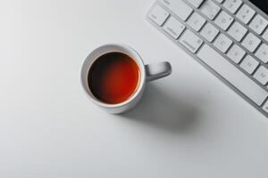 Computer mockup with coffee cup and sticky notes on a white desk providing a cozy and professional workspace background photo