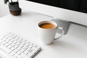 White desk featuring a computer mockup sticky notes and a coffee cup showcasing a professional and cozy workspace background photo