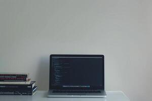 Laptop Mockup with Coding Books on Desk    and  Workspace Background photo