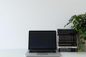 Laptop Mockup with Coding Books on Desk   Stylish and Effective Workspace Background photo