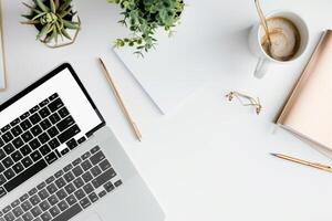 Laptop Mockup Background on white desk with pens and notepad for productivity photo