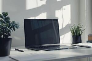 Laptop Mockup Background on white desk with productivity tools and notepad photo